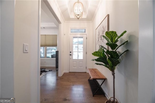 entrance foyer featuring hardwood / wood-style flooring, ornamental molding, and a notable chandelier