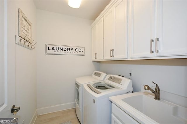 washroom featuring cabinets, light wood-type flooring, separate washer and dryer, and sink