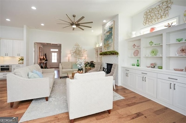 living room with ceiling fan and light hardwood / wood-style flooring