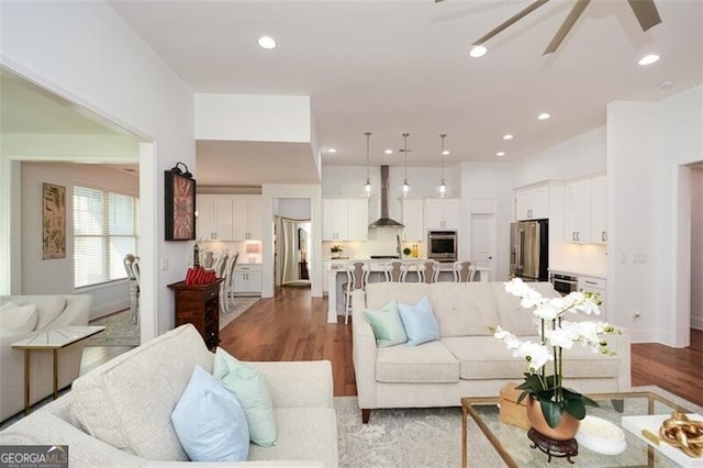 living room featuring ceiling fan and light hardwood / wood-style floors