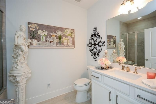 bathroom with vanity, toilet, and an enclosed shower