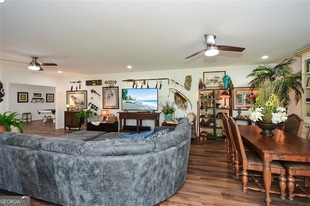 living room with ceiling fan and dark wood-type flooring