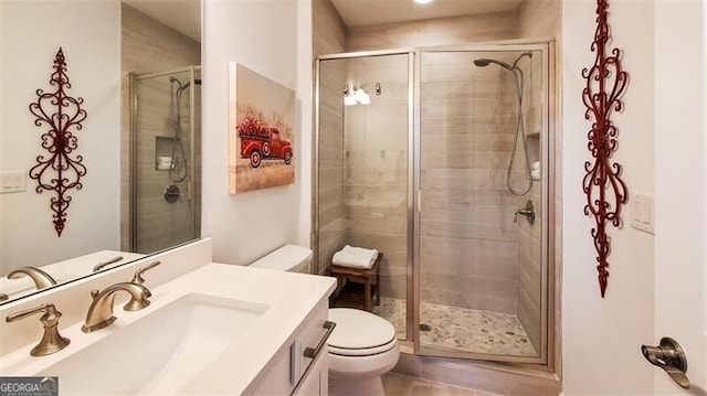 bathroom featuring vanity, toilet, and a shower with shower door