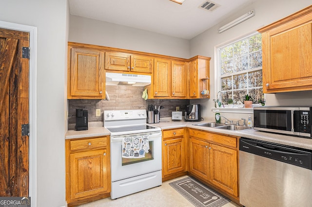 kitchen with sink, stainless steel appliances, and tasteful backsplash