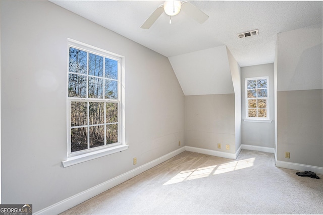 bonus room with a textured ceiling, ceiling fan, light carpet, and vaulted ceiling