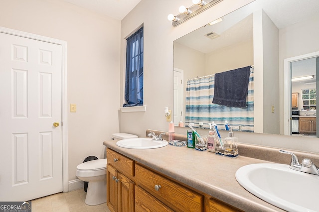 bathroom featuring toilet, vanity, and tile patterned floors