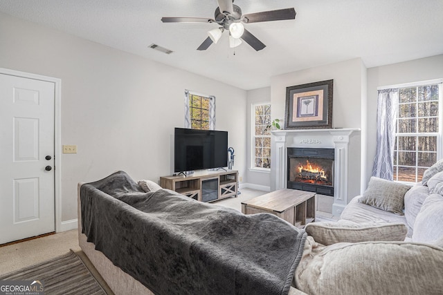 living room featuring carpet, a textured ceiling, a wealth of natural light, and ceiling fan