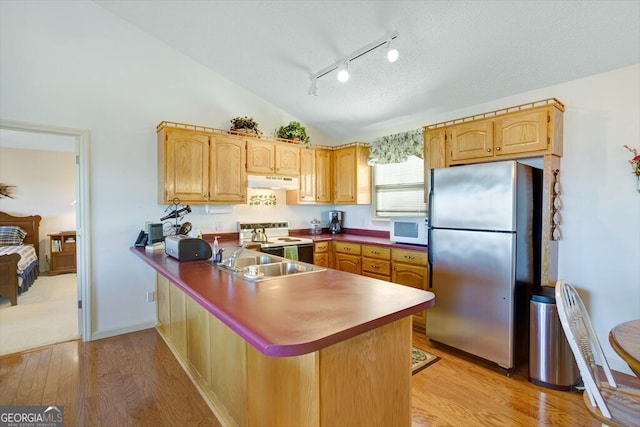 kitchen featuring white appliances, sink, vaulted ceiling, light wood-type flooring, and kitchen peninsula