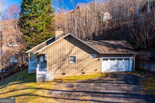 view of home's exterior with a lawn, a garage, and a wall unit AC