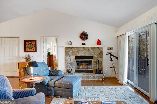 living room featuring hardwood / wood-style floors, lofted ceiling, and a fireplace