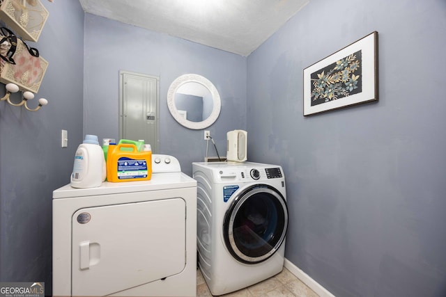 clothes washing area featuring washer and dryer, electric panel, and light tile patterned flooring