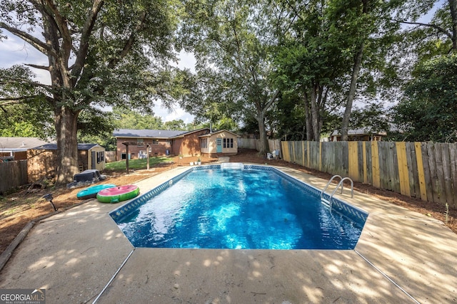 view of swimming pool featuring a patio area and an outdoor structure