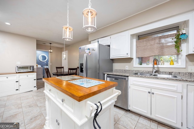 kitchen featuring a kitchen island, sink, white cabinetry, and stainless steel appliances