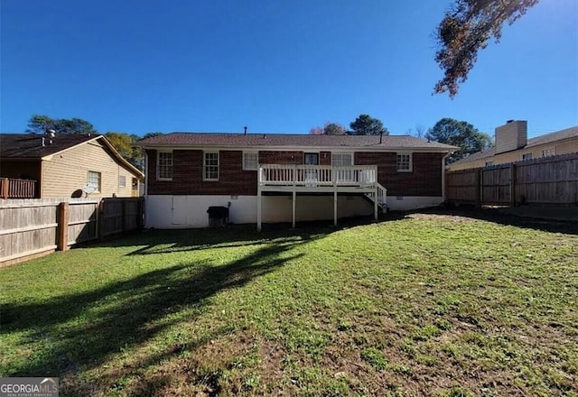 back of property with a yard and a deck