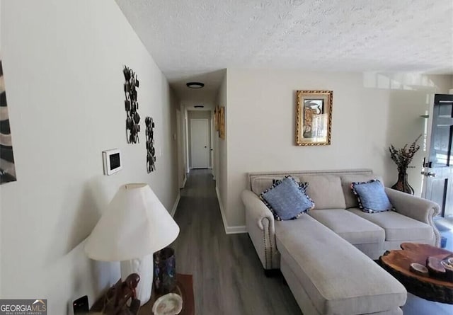 living room featuring dark wood-type flooring and a textured ceiling