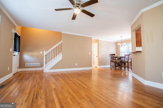 unfurnished living room with ceiling fan with notable chandelier, light hardwood / wood-style flooring, and ornamental molding