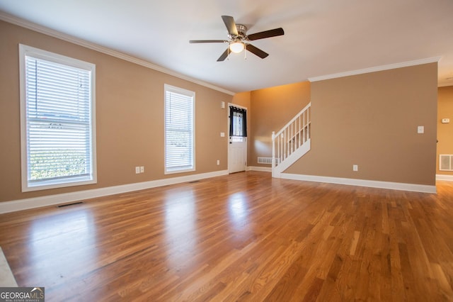 unfurnished living room featuring ceiling fan, hardwood / wood-style floors, a healthy amount of sunlight, and ornamental molding