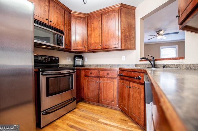 kitchen with ceiling fan, light wood-type flooring, and appliances with stainless steel finishes