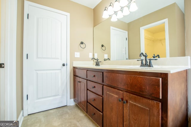 bathroom featuring tile patterned flooring, vanity, and an inviting chandelier