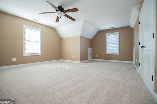 bonus room featuring plenty of natural light, ceiling fan, light colored carpet, and lofted ceiling