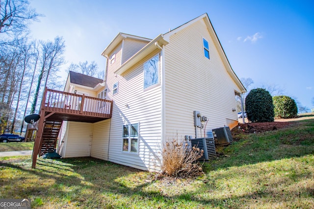 view of property exterior featuring a deck, cooling unit, and a lawn