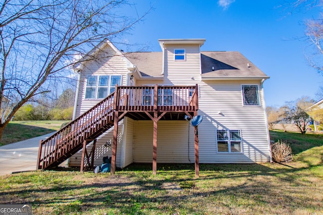 rear view of property featuring a yard and a deck