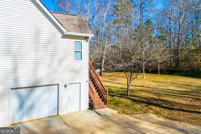 view of side of home featuring a garage and a lawn