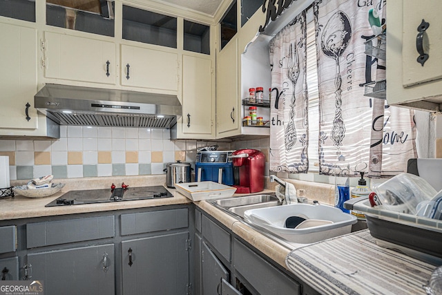 kitchen featuring gray cabinetry, ventilation hood, sink, black electric cooktop, and tasteful backsplash