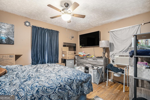 bedroom featuring ceiling fan, cooling unit, a textured ceiling, and light hardwood / wood-style flooring