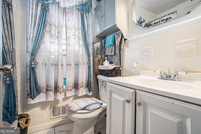 bathroom with vanity, toilet, and tile walls