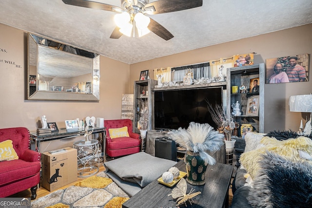 living room with ceiling fan and a textured ceiling