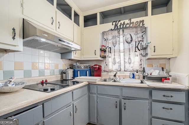 kitchen with backsplash, gray cabinets, black electric cooktop, and sink