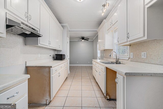 kitchen featuring light tile patterned floors, backsplash, white cabinetry, ceiling fan, and under cabinet range hood