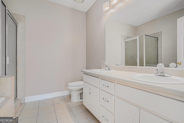 bathroom featuring a stall shower, a sink, and tile patterned floors