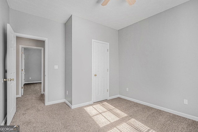 unfurnished bedroom featuring light carpet, ceiling fan, and baseboards