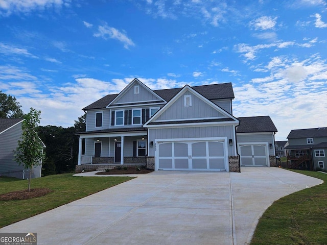 craftsman-style home with covered porch, a garage, and a front lawn