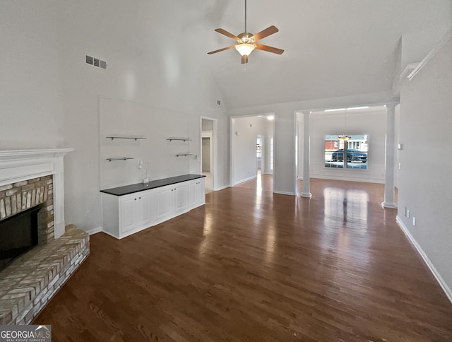 unfurnished living room featuring a fireplace, high vaulted ceiling, ceiling fan, and dark wood-type flooring