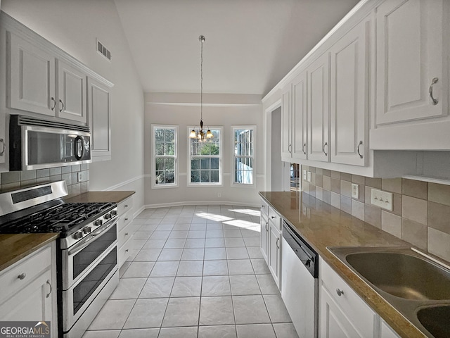 kitchen featuring lofted ceiling, white cabinetry, stainless steel appliances, and tasteful backsplash