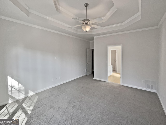 carpeted empty room with a raised ceiling, ceiling fan, and crown molding