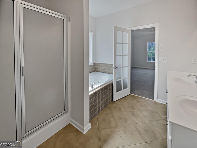 bathroom featuring plus walk in shower, french doors, vanity, and tile patterned floors