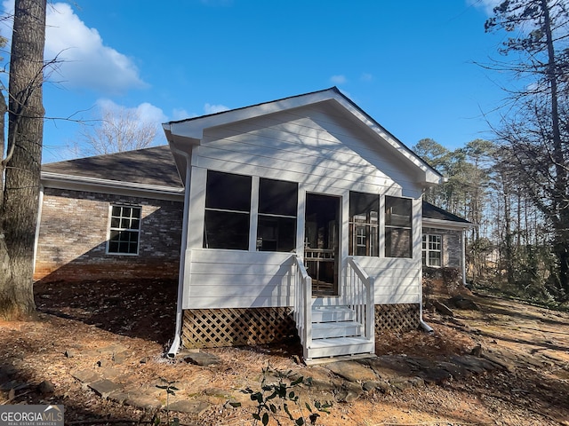 rear view of property featuring a sunroom