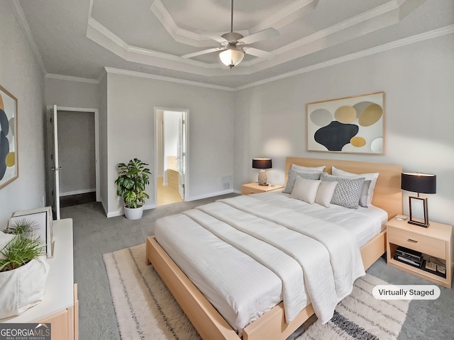 bedroom featuring ensuite bath, ceiling fan, crown molding, a tray ceiling, and carpet