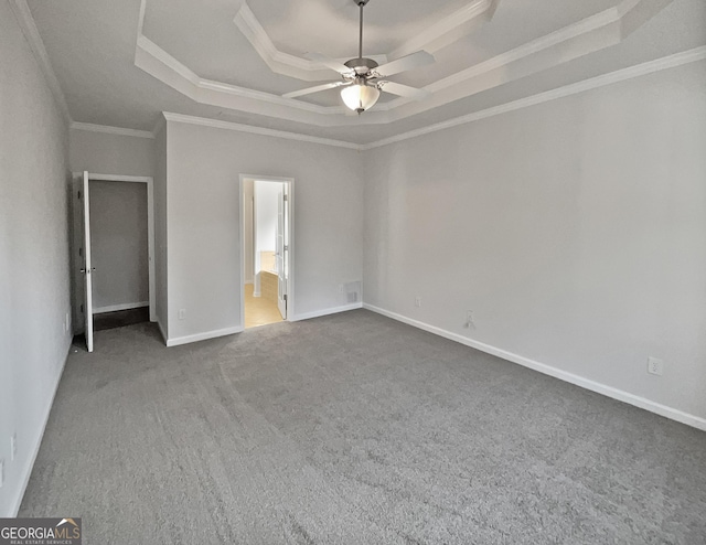 unfurnished bedroom featuring carpet flooring, ornamental molding, a tray ceiling, ceiling fan, and connected bathroom