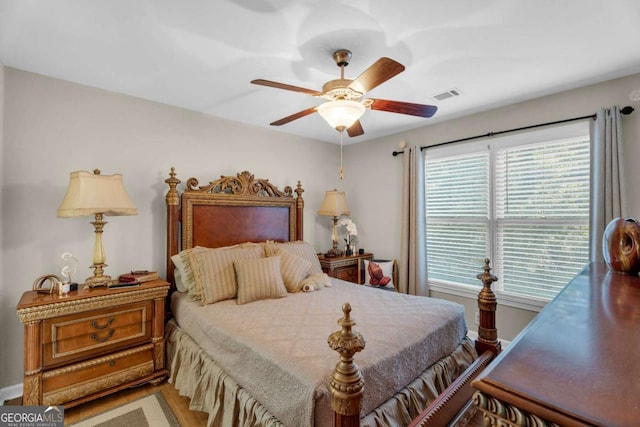 bedroom with multiple windows, hardwood / wood-style floors, and ceiling fan