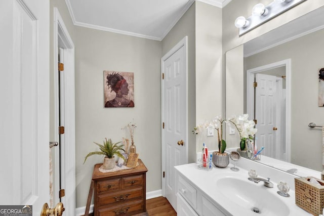 bathroom with hardwood / wood-style floors, vanity, and ornamental molding