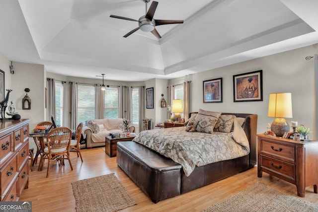 bedroom featuring a tray ceiling, light hardwood / wood-style flooring, and ceiling fan