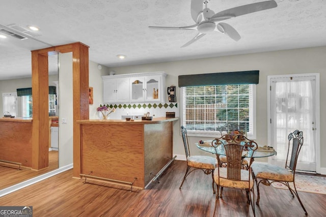 dining room featuring hardwood / wood-style floors, a textured ceiling, and ceiling fan