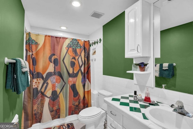 bathroom featuring curtained shower, vanity, tile walls, and toilet