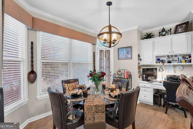 dining room featuring ornamental molding, light wood-type flooring, and an inviting chandelier