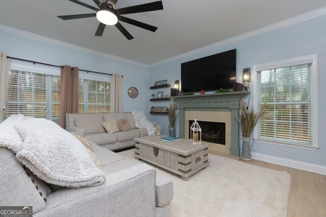 4492 Bryten Dr, Douglasville, GA 30135 - living room with crown molding, a ceiling fan, a premium fireplace, wood finished floors, and baseboards